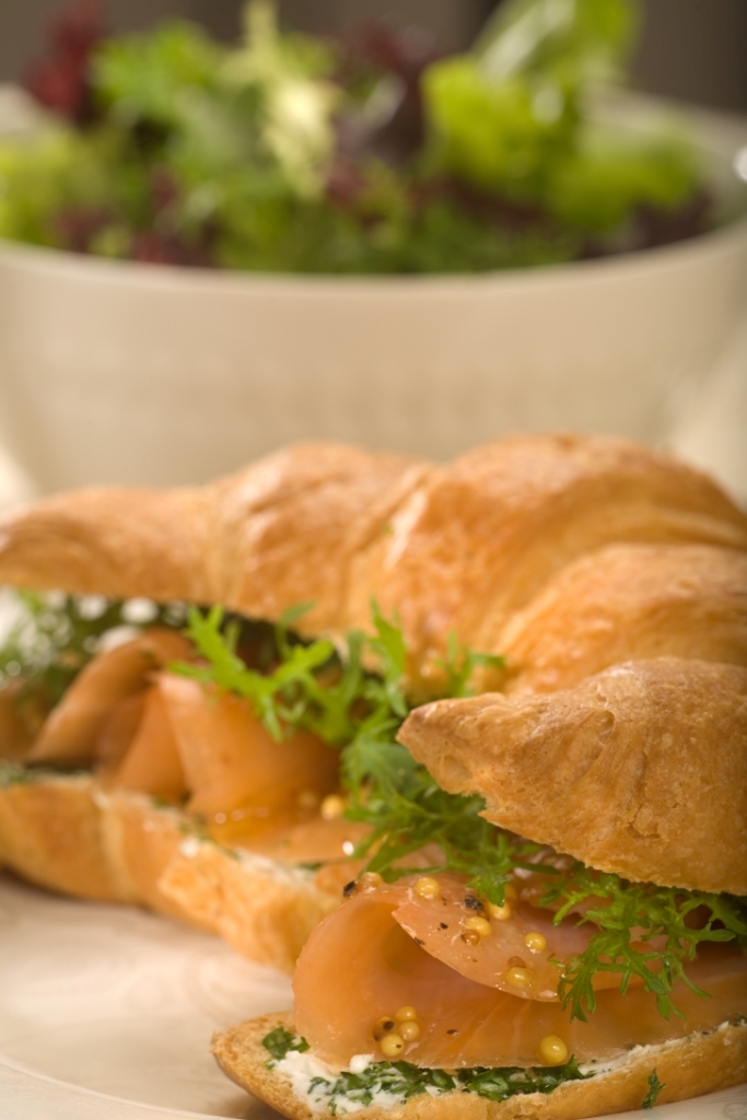 Croissant z kolorowymi sałatami, twarogiem ziołowym i plastrami wędzonego łososia norweskiego